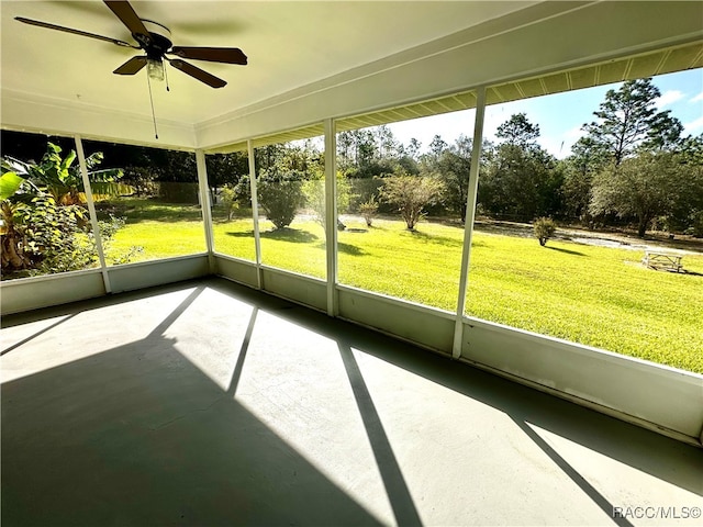 unfurnished sunroom featuring ceiling fan