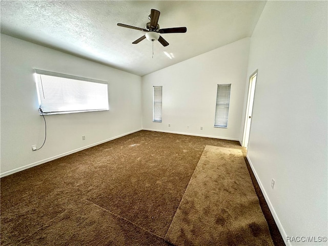 unfurnished room with a textured ceiling, dark carpet, ceiling fan, and lofted ceiling