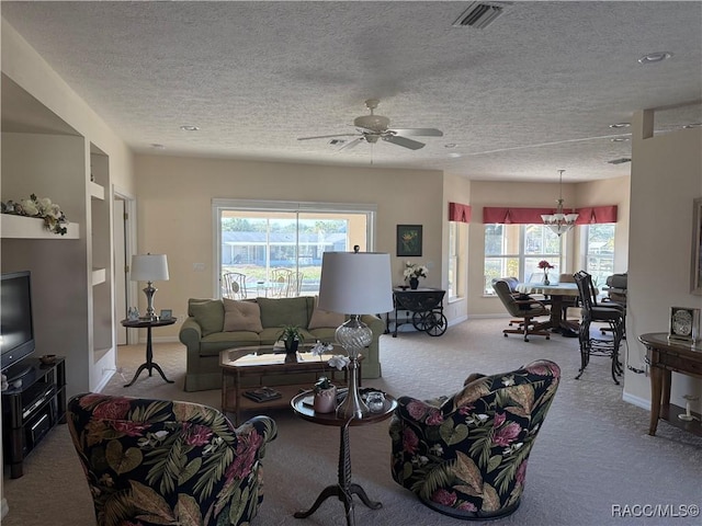 carpeted living room featuring ceiling fan with notable chandelier and a textured ceiling