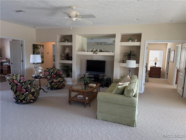 carpeted living room featuring ceiling fan, built in features, and a textured ceiling