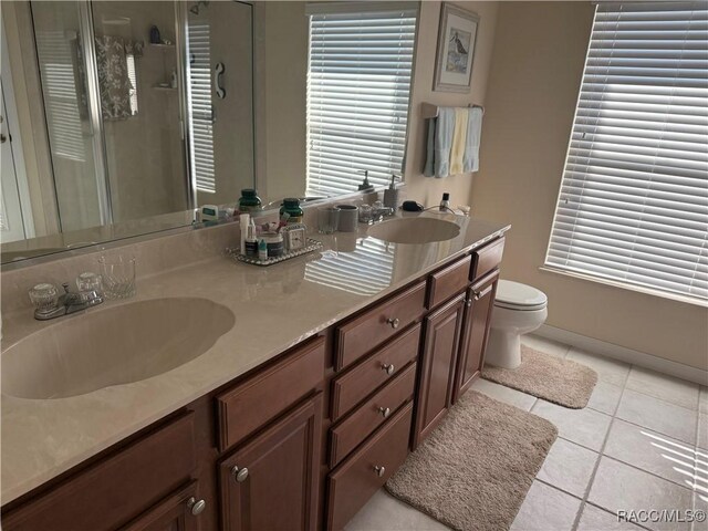 3926 N Eagle Pt, Crystal River, FL 34428 - bathroom featuring a stall shower, double vanity, toilet, tile patterned floors, and baseboards