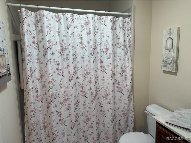 bathroom with vanity, toilet, and curtained shower