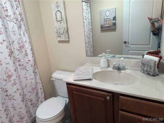 bathroom featuring vanity, toilet, and walk in shower