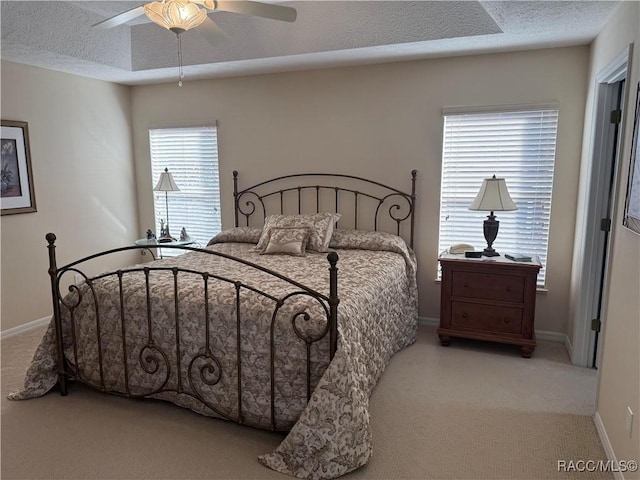 carpeted bedroom with ceiling fan and a textured ceiling