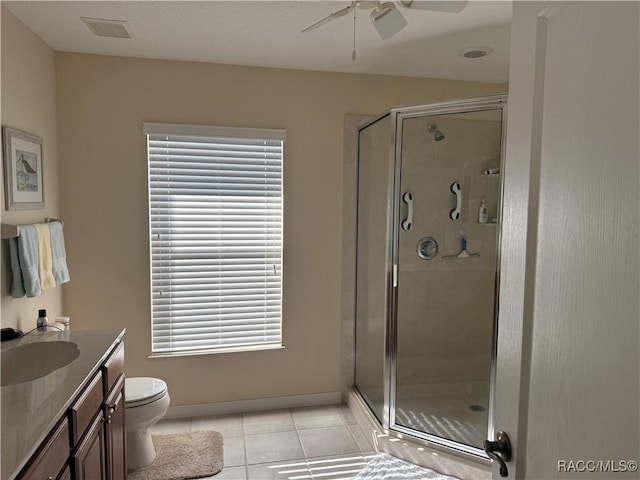 bathroom featuring a shower with shower door, vanity, ceiling fan, toilet, and tile patterned floors