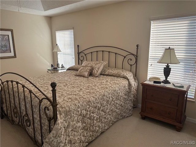 bedroom featuring light carpet and a textured ceiling