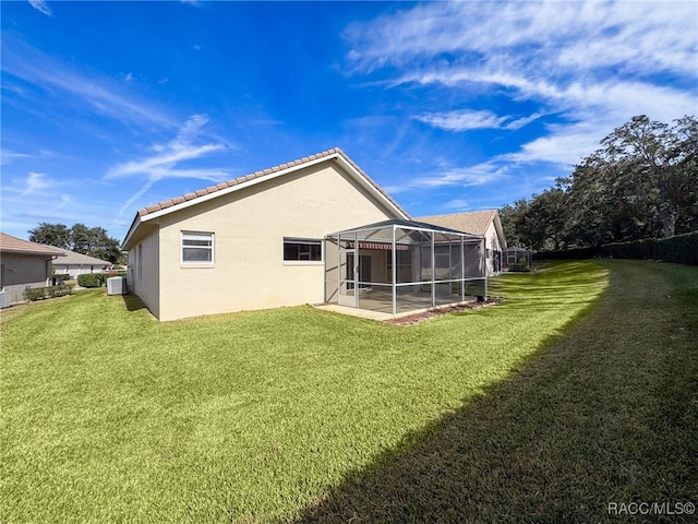 back of house featuring a yard, a patio, and glass enclosure