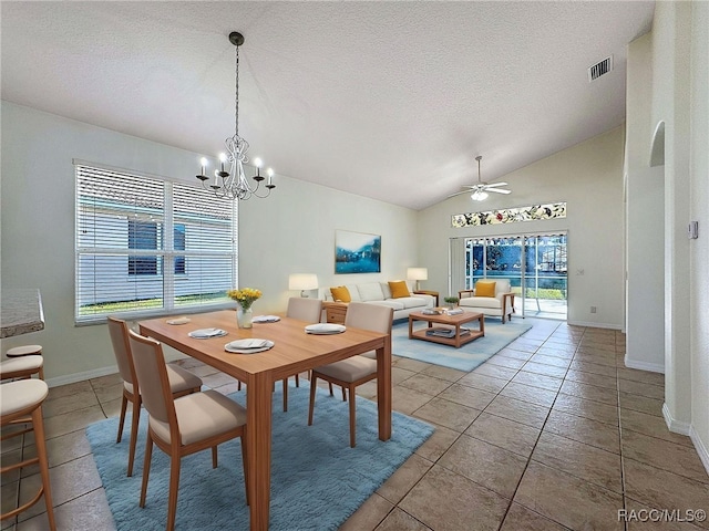 tiled dining area with ceiling fan with notable chandelier, vaulted ceiling, and a textured ceiling