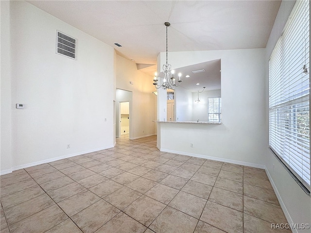 interior space with lofted ceiling, light tile patterned floors, and a notable chandelier