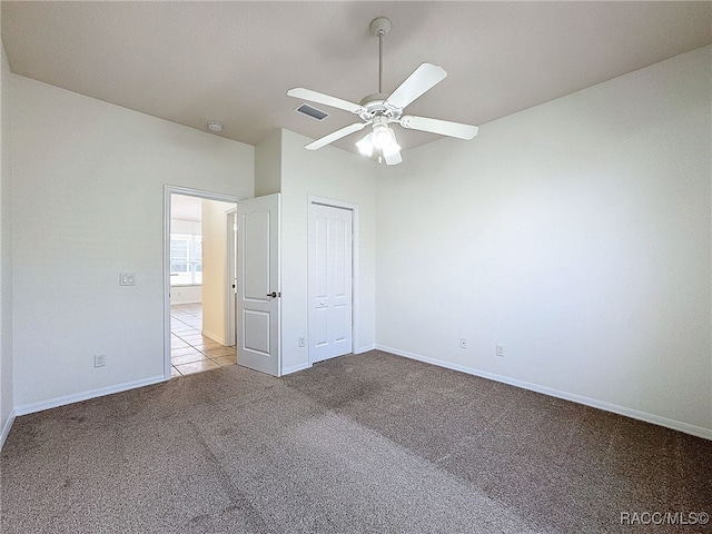 unfurnished bedroom with lofted ceiling, light colored carpet, a closet, and ceiling fan