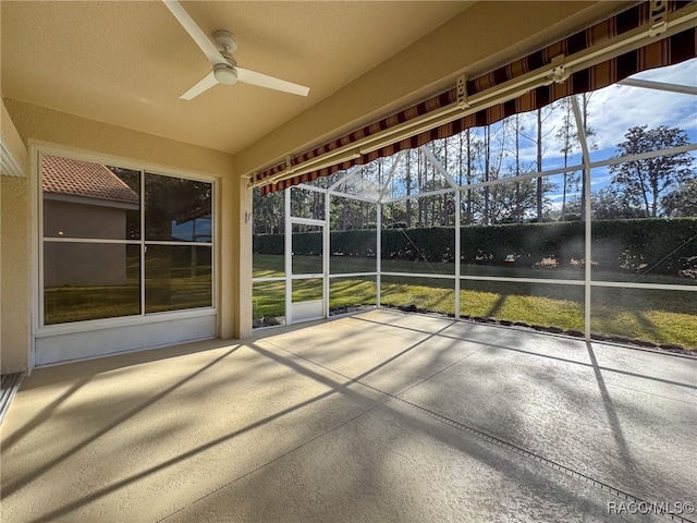 unfurnished sunroom featuring ceiling fan