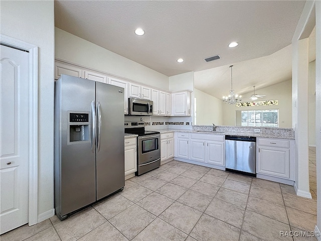 kitchen featuring pendant lighting, sink, stainless steel appliances, white cabinets, and vaulted ceiling