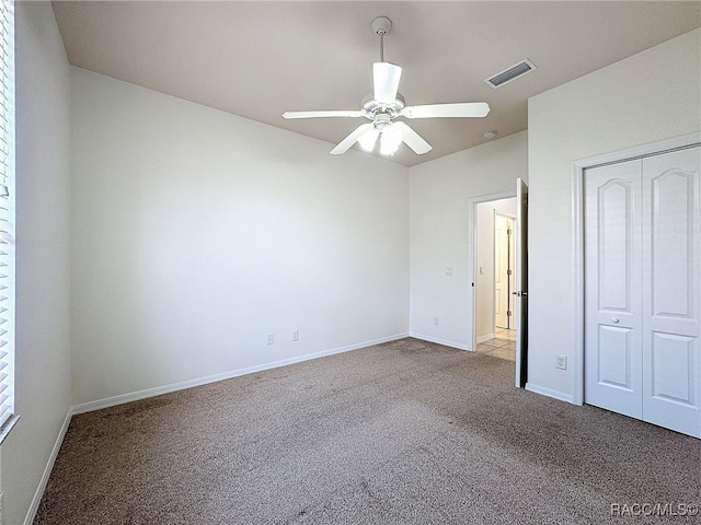 unfurnished bedroom with light colored carpet, a closet, and ceiling fan