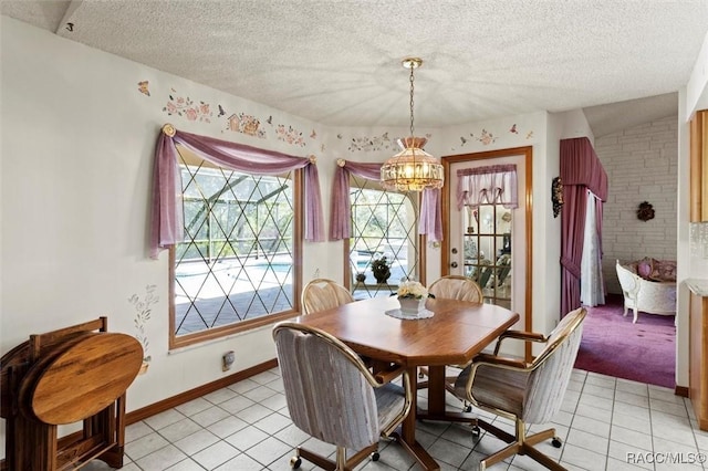 dining space featuring light tile patterned floors, baseboards, a textured ceiling, and an inviting chandelier