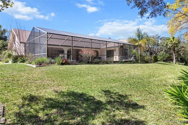 rear view of property with glass enclosure and a yard