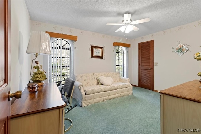 living area with baseboards, carpet floors, a textured ceiling, and ceiling fan