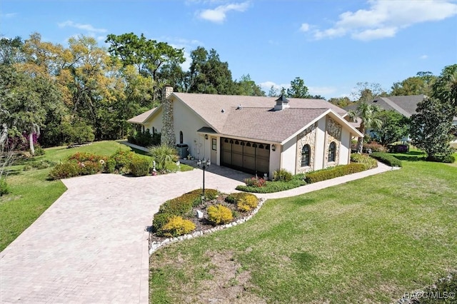 view of front of home with a front yard, decorative driveway, a garage, and a chimney