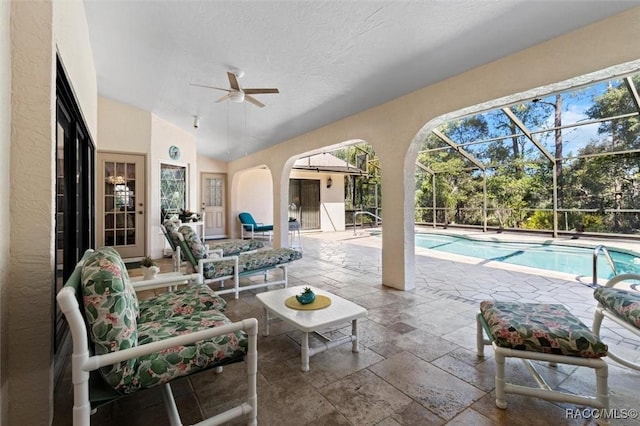 view of patio / terrace with a lanai, an outdoor pool, and ceiling fan