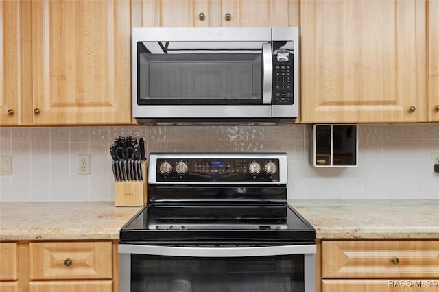 kitchen with range with electric cooktop, light brown cabinets, stainless steel microwave, decorative backsplash, and light stone countertops