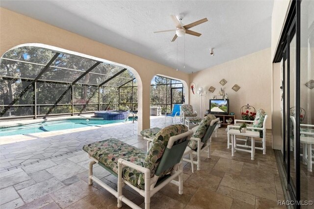 view of patio featuring a lanai, a pool with connected hot tub, and a ceiling fan