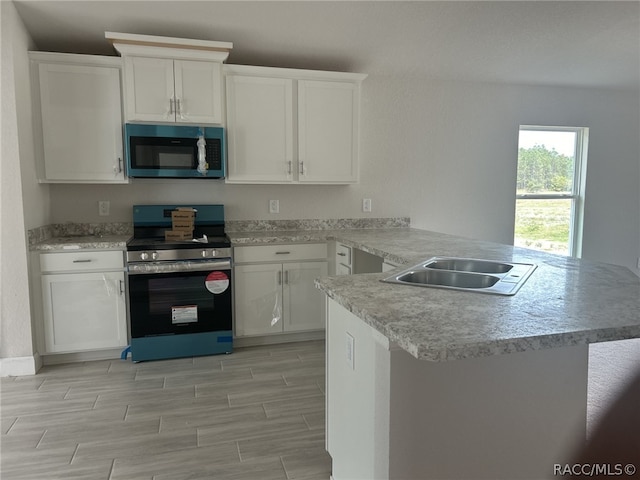 kitchen featuring white cabinets, stainless steel appliances, kitchen peninsula, and sink