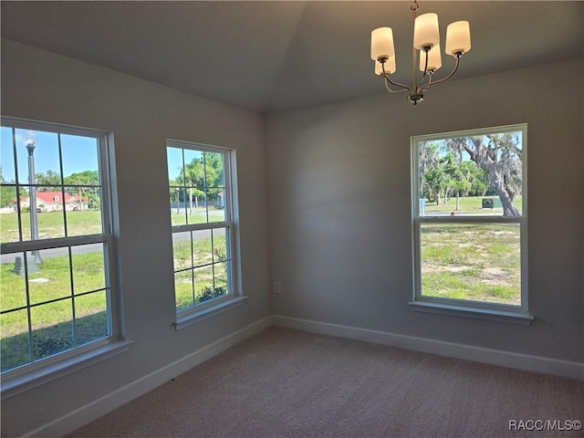 1280 Heron Point Dr, Inverness, FL 34453 - carpeted spare room with baseboards, a wealth of natural light, and a notable chandelier