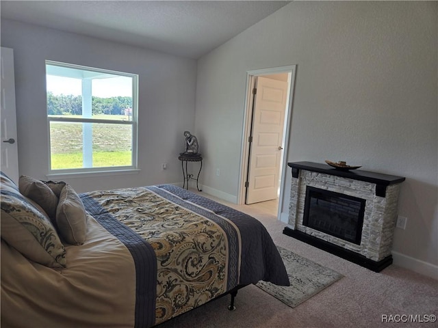 1280 Heron Point Dr, Inverness, FL 34453 - bedroom featuring vaulted ceiling, carpet flooring, baseboards, and a stone fireplace