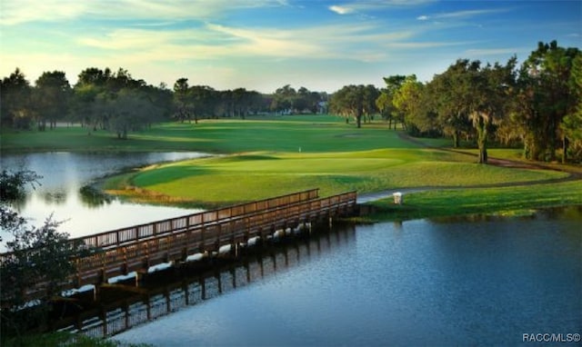 view of home's community featuring view of golf course, a water view, and a lawn