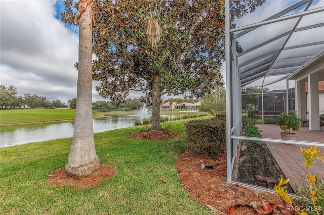 view of yard featuring glass enclosure and a water view