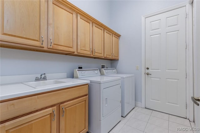 washroom featuring light tile patterned floors, separate washer and dryer, a sink, and cabinet space