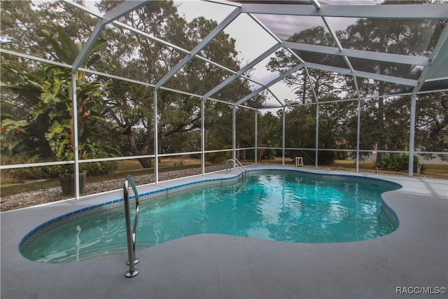 view of swimming pool featuring glass enclosure and a patio area