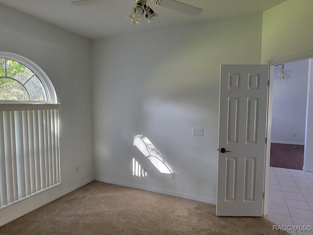 unfurnished room with light colored carpet and ceiling fan