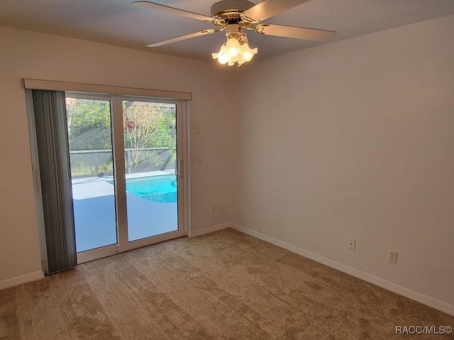 carpeted spare room featuring ceiling fan