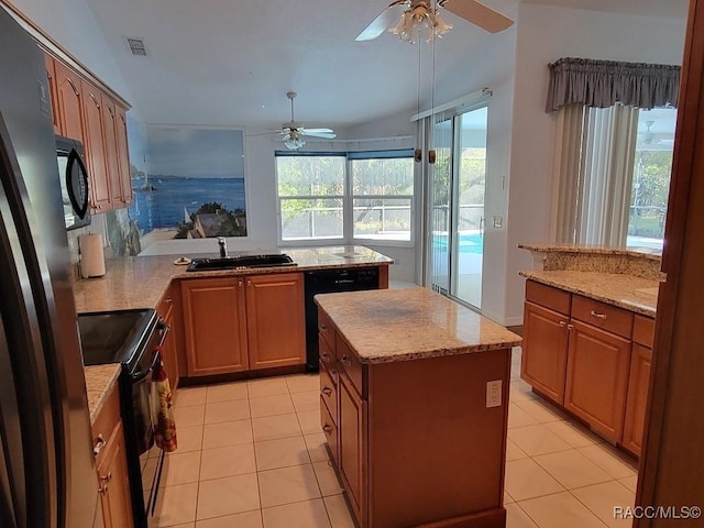 kitchen featuring sink, black appliances, a center island, lofted ceiling, and light tile patterned flooring