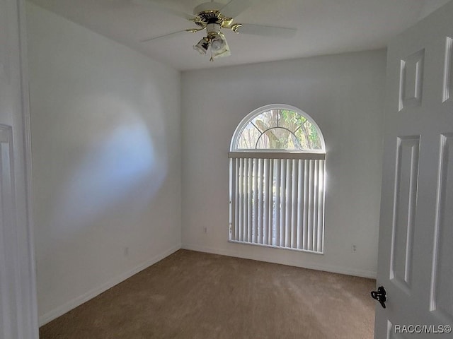 spare room featuring light carpet and ceiling fan