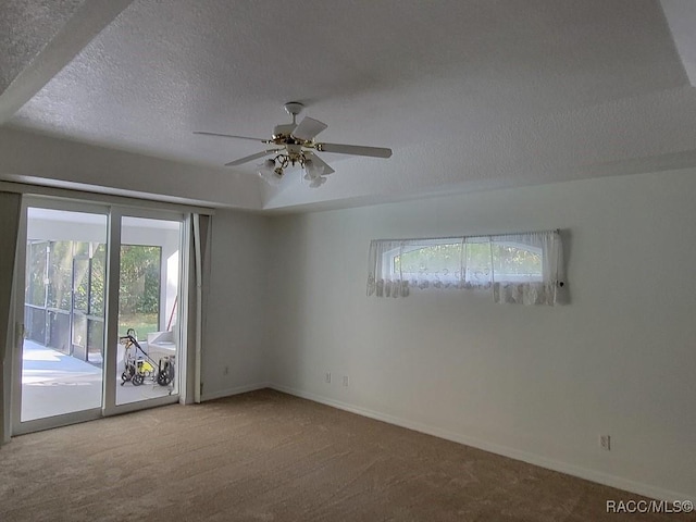 carpeted spare room with ceiling fan and a textured ceiling