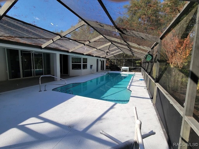 view of pool featuring glass enclosure and a patio area