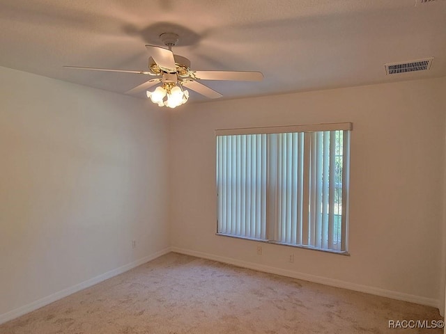 carpeted spare room with ceiling fan