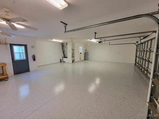 garage featuring electric water heater, a garage door opener, and ceiling fan