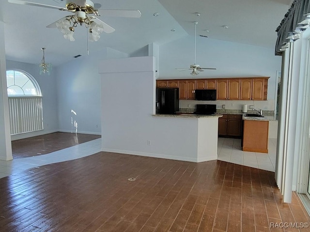 kitchen with black appliances, ceiling fan with notable chandelier, sink, and hardwood / wood-style floors