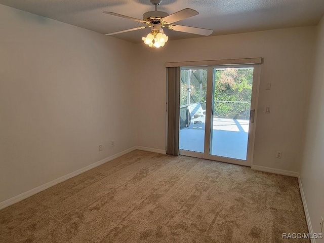 carpeted empty room featuring a textured ceiling and ceiling fan