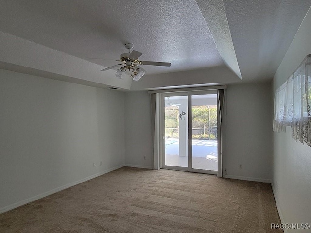 unfurnished room featuring a textured ceiling, light colored carpet, and ceiling fan