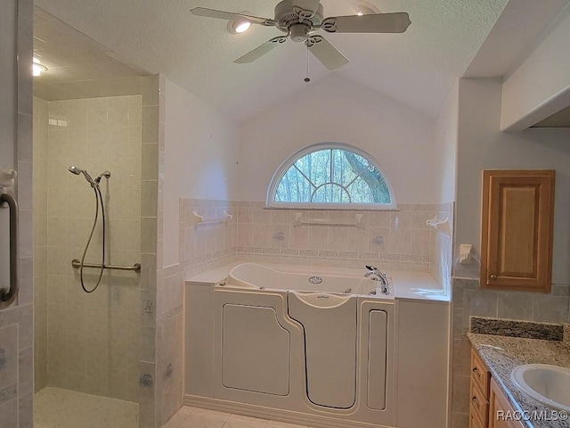 bathroom featuring a textured ceiling, vaulted ceiling, tile walls, and ceiling fan