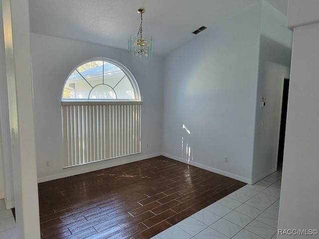 unfurnished room with hardwood / wood-style floors and a chandelier