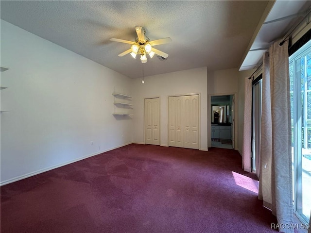 unfurnished bedroom featuring carpet floors, baseboards, two closets, and a textured ceiling