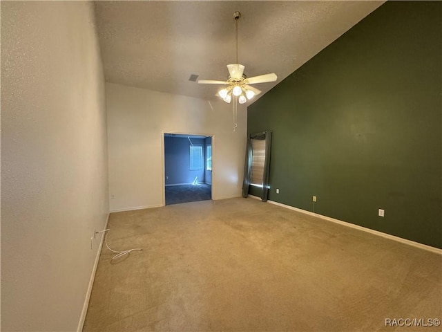 carpeted spare room with baseboards, a ceiling fan, high vaulted ceiling, and a textured ceiling