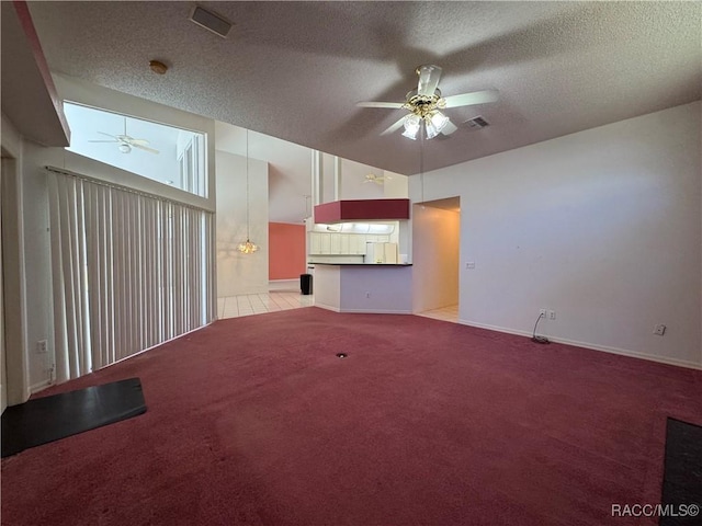 unfurnished living room featuring ceiling fan, carpet flooring, and a textured ceiling