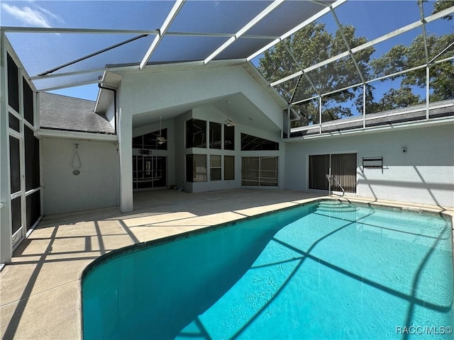outdoor pool with glass enclosure and a patio