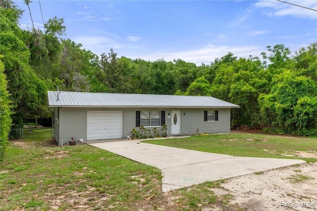 3184 N Edward Island Pt, Hernando, FL 34442 - ranch-style house with driveway, an attached garage, a front lawn, metal roof, and a view of trees