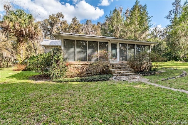 3184 N Edward Island Pt, Hernando, FL 34442 - view of front of home with a sunroom, a front yard, and metal roof